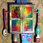 mixed media assemblage: old wood cabinet, wooden utensils, painted sticks, collage, acrylic paint, watercolor